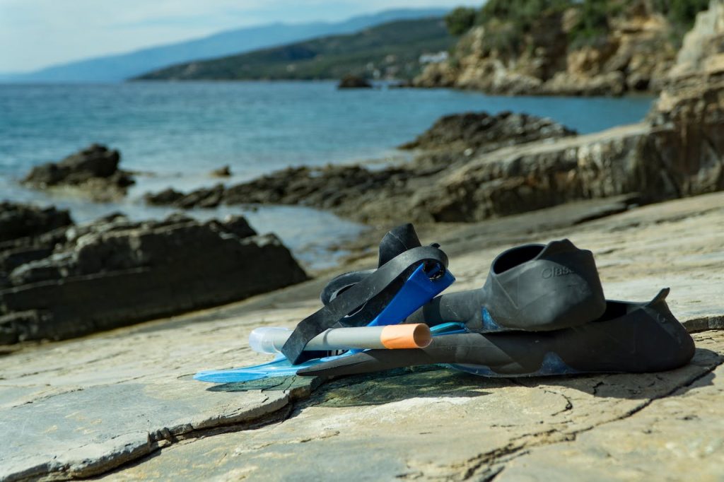 a snorkel mask and fins lying on the rocks.